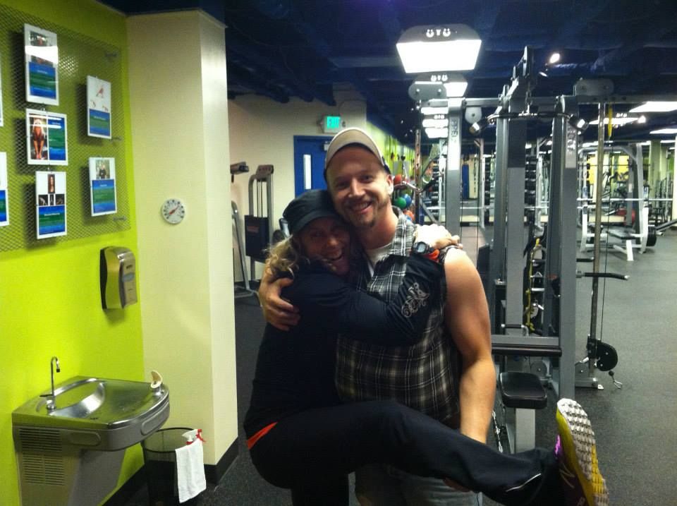 Karie and a longtime member hugging on the old gym floor, years ago