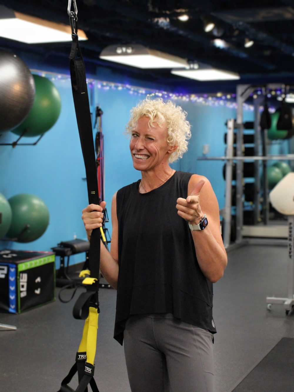 Cara, personal trainer, coaching with a TRX strap