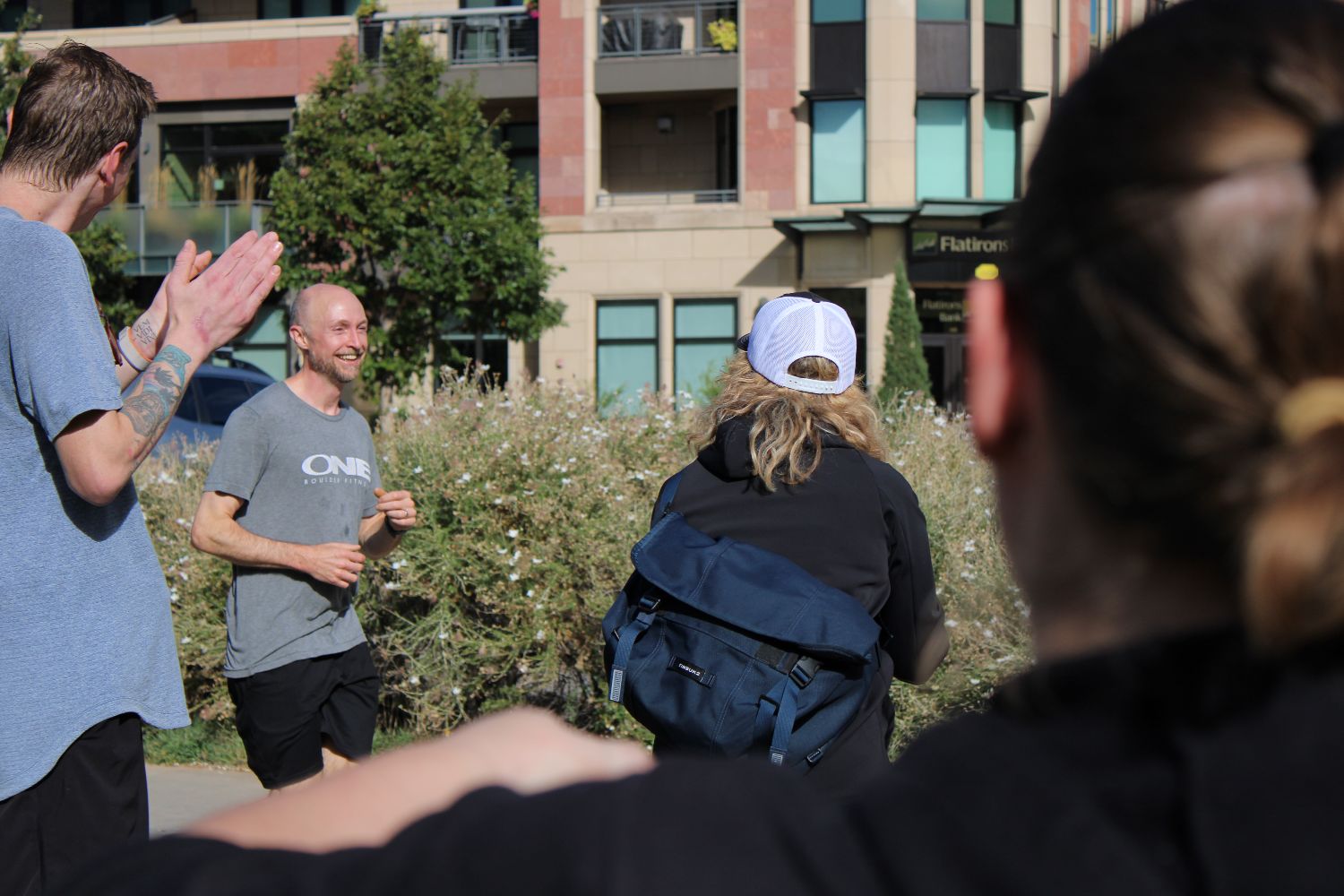 Members clapping a runner through on a downtown Boulder path
