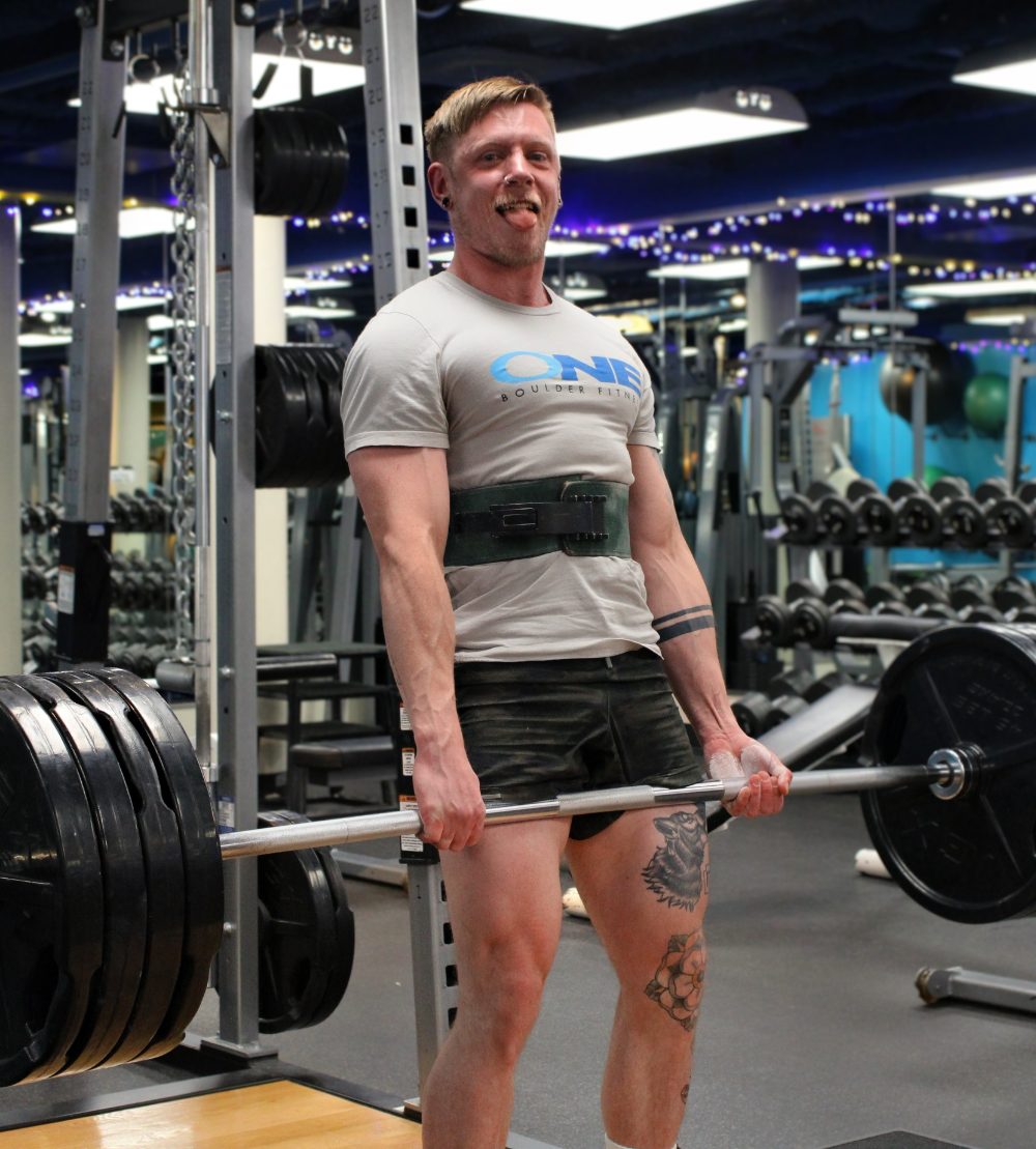 Joe, trainer and nutrition coach, holding a weight plate