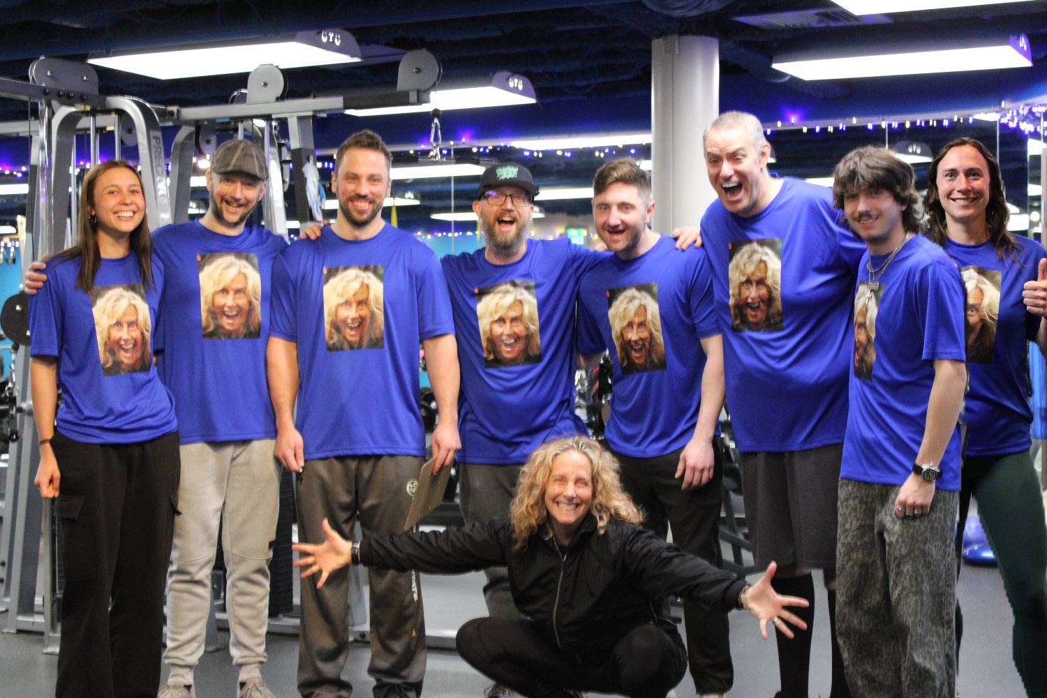The ONE Boulder Fitness trainers on the gym floor, laughing in matching shirts printed with owner Karie’s face